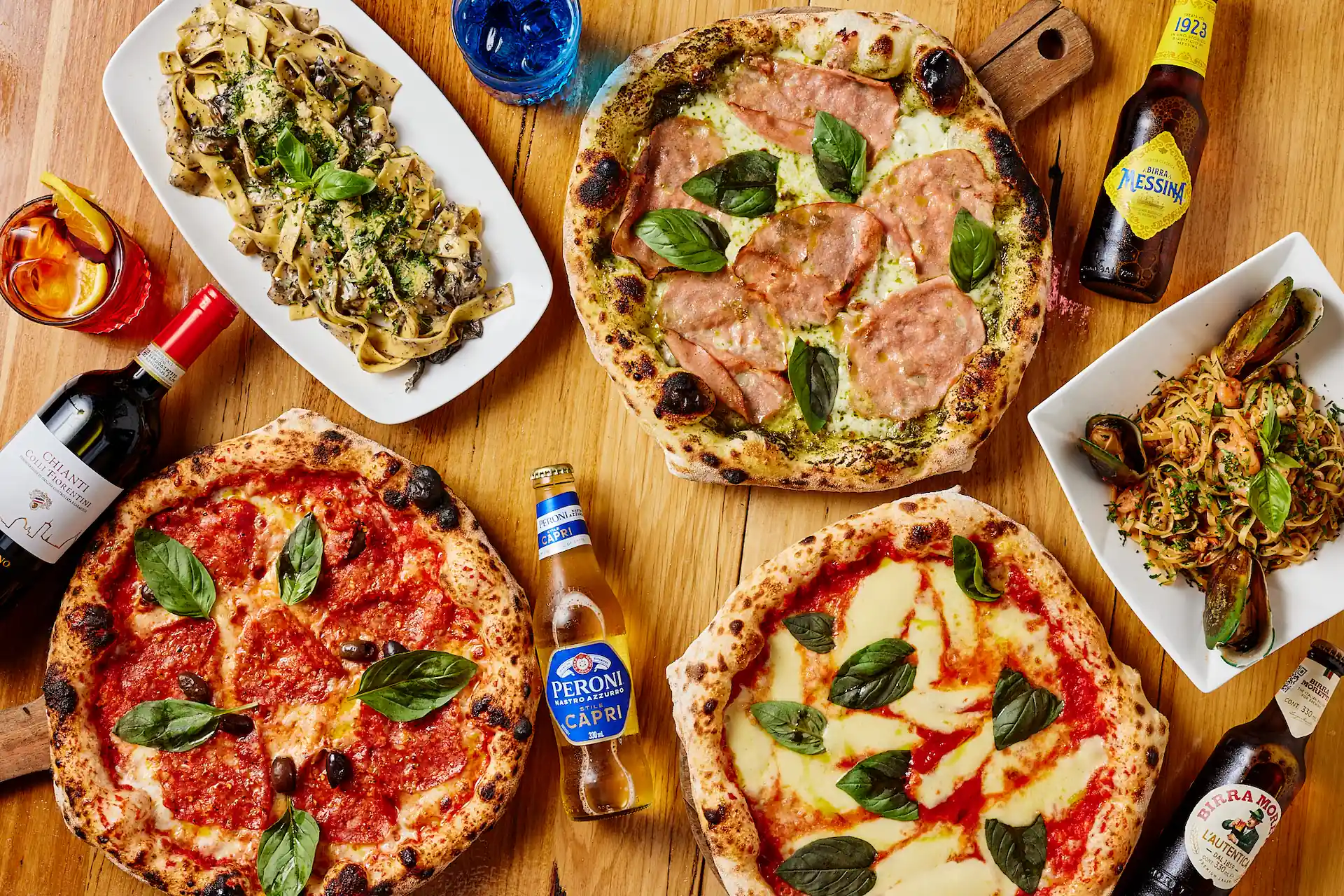 St Domenico — Neapolitan pizzas and pasta spread on rustic wooden table